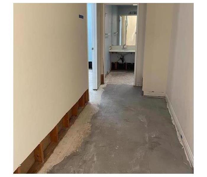 Hallway down to the concrete flooring with drywall stripped away.